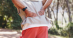 Man, hands and fitness in nature with back pain, muscle spasm and hiking injury. Male person, trekking and sore in forest with exercise burnout, joint inflammation and massage to relieve tension
