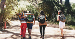 Behind, hiking and travel with group of friends outdoor in forest for hobby or journey. Hug, trekking and walking with hiker people on trail in nature together for adventure, backpacking or bonding