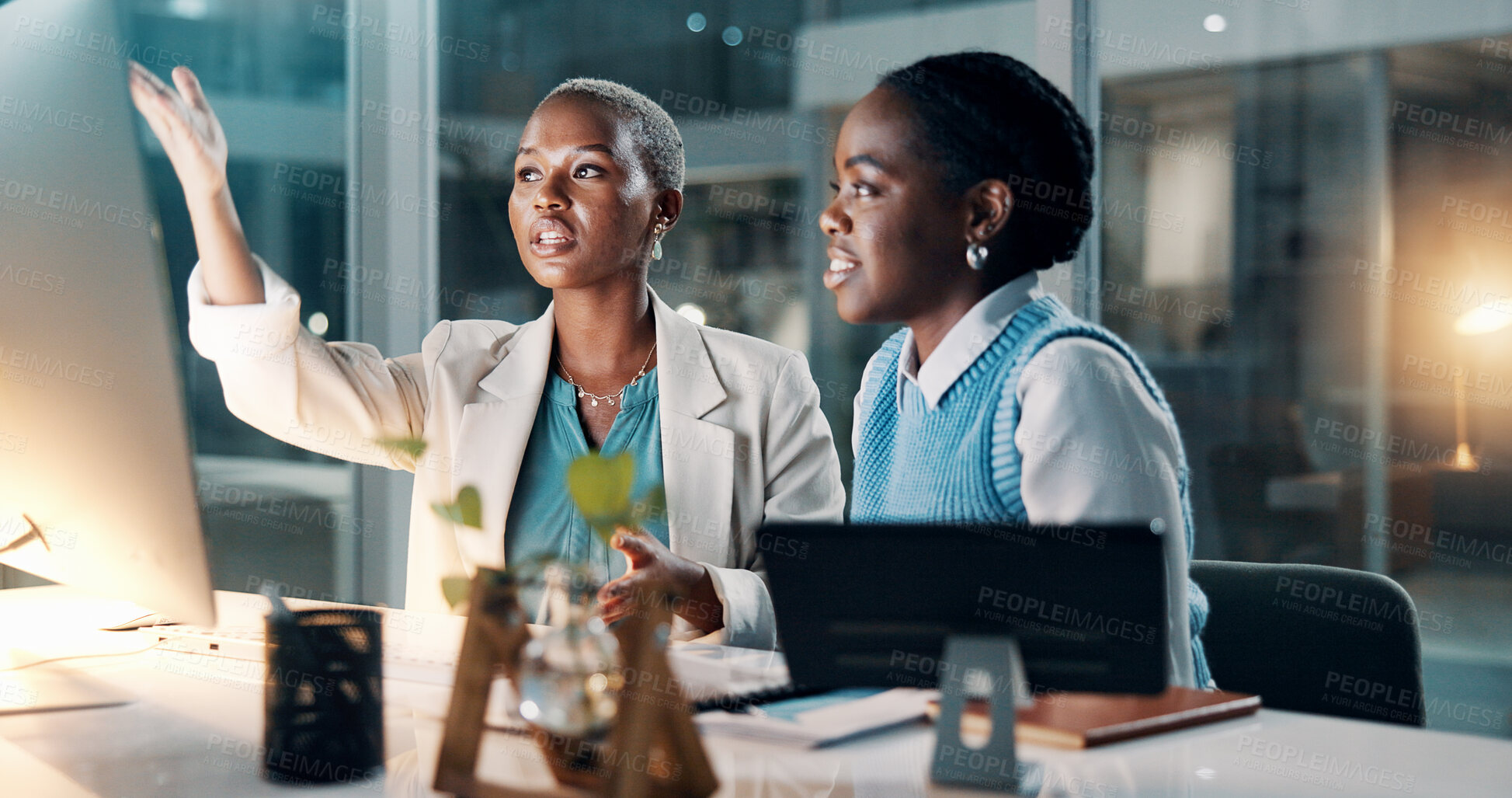 Buy stock photo Night, businesswomen and talk in office with computer, financial review or deadline for company audit. Late, black people and point in workplace with desktop, finance discussion or accounting report.