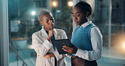 Buy stock photo Night, business people and talk in office with tablet, financial review and deadline for company audit. Late, black women and conversation with tech, problem solving and advice for accounting report.