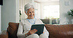 Tablet, happy and senior woman on sofa in home with online blog, social media or headlines. Reading, digital technology and elderly female person with app for news in living room with relax at house.