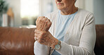 Senior woman, hands and wrist pain with injury on sofa for carpal tunnel syndrome in home. Closeup, elderly or female person with sore arm or ache for joint inflammation, arthritis or muscle tension