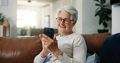 Buy stock photo Old woman, smile and typing in home with phone, browsing and social media gossip for entertainment. Happy, elderly person and scroll on sofa with tech, text message and mobile app for reading news.