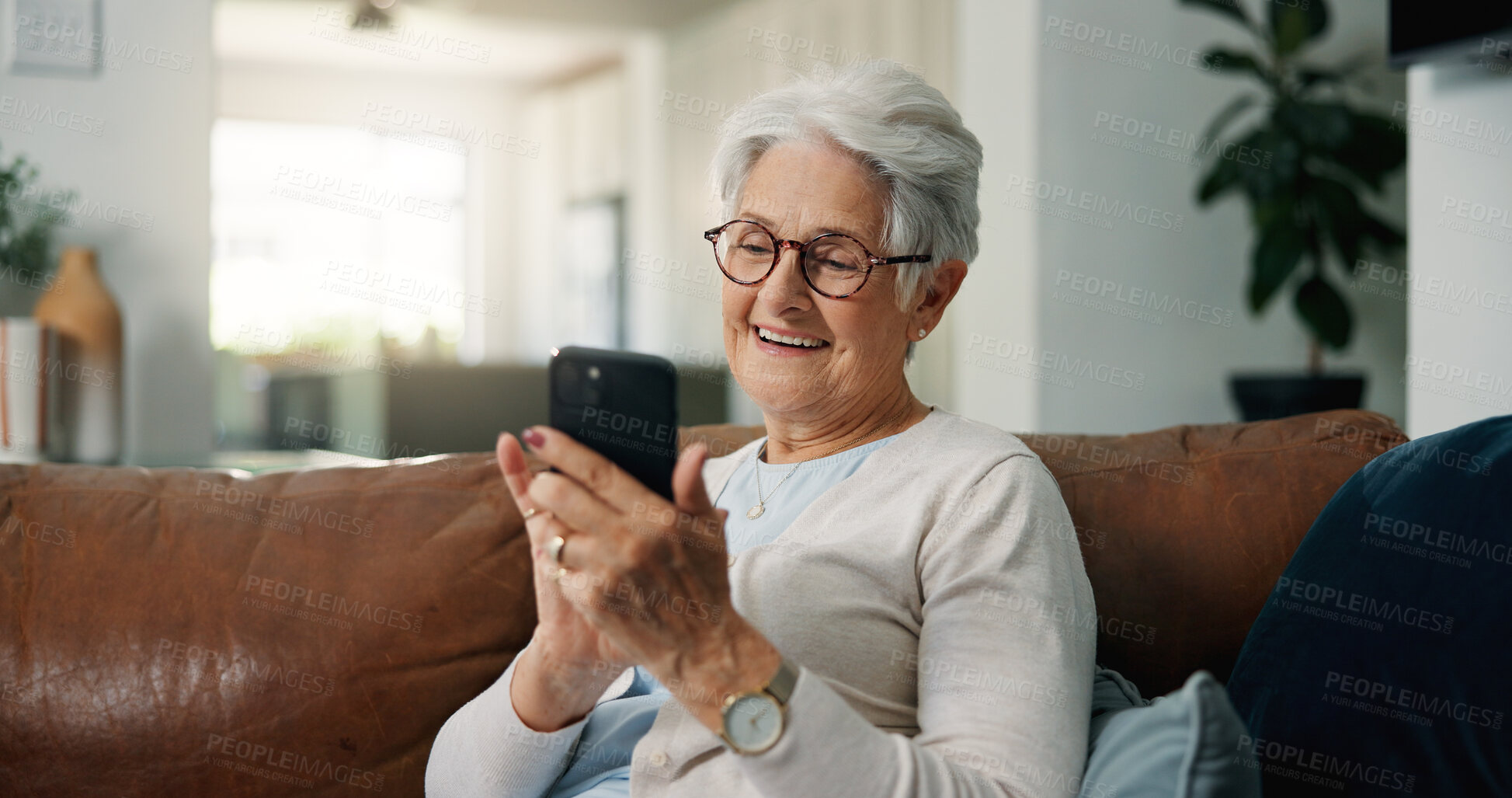 Buy stock photo Old woman, smile and typing in home with phone, browsing and social media gossip for entertainment. Happy, elderly person and scroll on sofa with tech, text message and mobile app for reading news.