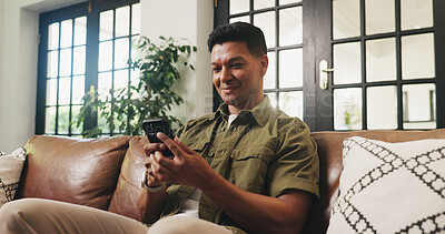 Buy stock photo Smile, man and relax with phone at sofa for communication, social media and browsing website. Happy, male person and mobile for reading chat on app, download games and message notification at house