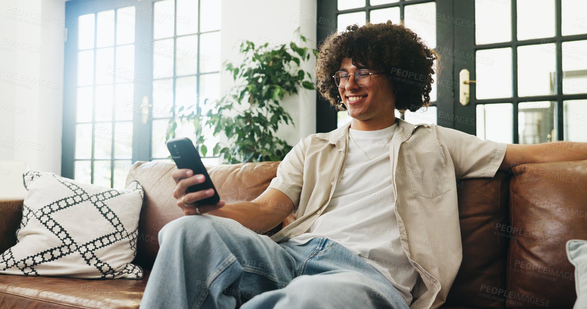 Buy stock photo Relax, sofa and happy man with phone for browsing, internet website and connection for playing games. Mobile app, digital entertainment or gamer with typing for cheat command, virtual world and home