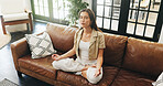 Woman, yoga and meditation on sofa with lotus, mindfulness and breathing exercise in home. Person, zen and mudra on couch with holistic fitness, wellness and above in living room at apartment
