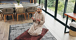 Above, man and praying salah at house with faith, praise Allah and spiritual worship in Ramadan. Islamic, muslim person or prayer with dua, religious practice and devotion to God for belief in lounge