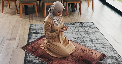 Buy stock photo Muslim, woman and praying in home for religion, faith and dua on Ramadan Kareem for peace. Islam, holy prayer and person worship God with spiritual devotion, salah and praise Allah on mat in house