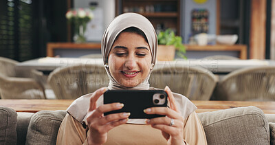 Buy stock photo Muslim woman, phone and streaming on couch for movie, subscription app or watch series for entertainment. Film website, video platform and happy person with hijab in home, mobile or relax on weekend