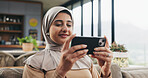 Muslim woman, phone and streaming in lounge for movie, subscription app and watch series for entertainment. Drama film, video platform and happy person with hijab in home, mobile and relax on weekend