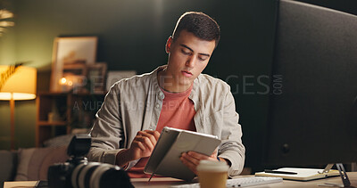 Buy stock photo Man, photographer and tablet in home at night for editing, review images and content creator. Male person, digital and website with creative effects, check quality and deadline for media production