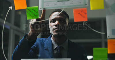 Buy stock photo Glass wall, night or black man in office with review, strategy or planning for report. Problem solving, sticky note or employee with insight, idea board or brainstorming deadline on evening shift.