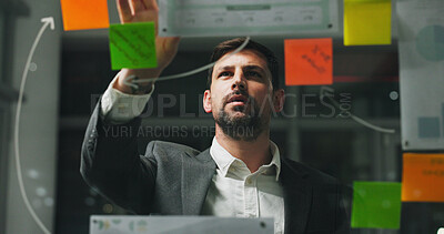 Buy stock photo Glass wall, night or man in agency with sticky note, strategy or planning for report. Thinking, problem solving or employee in office with paper, idea board or brainstorming deadline on evening shift