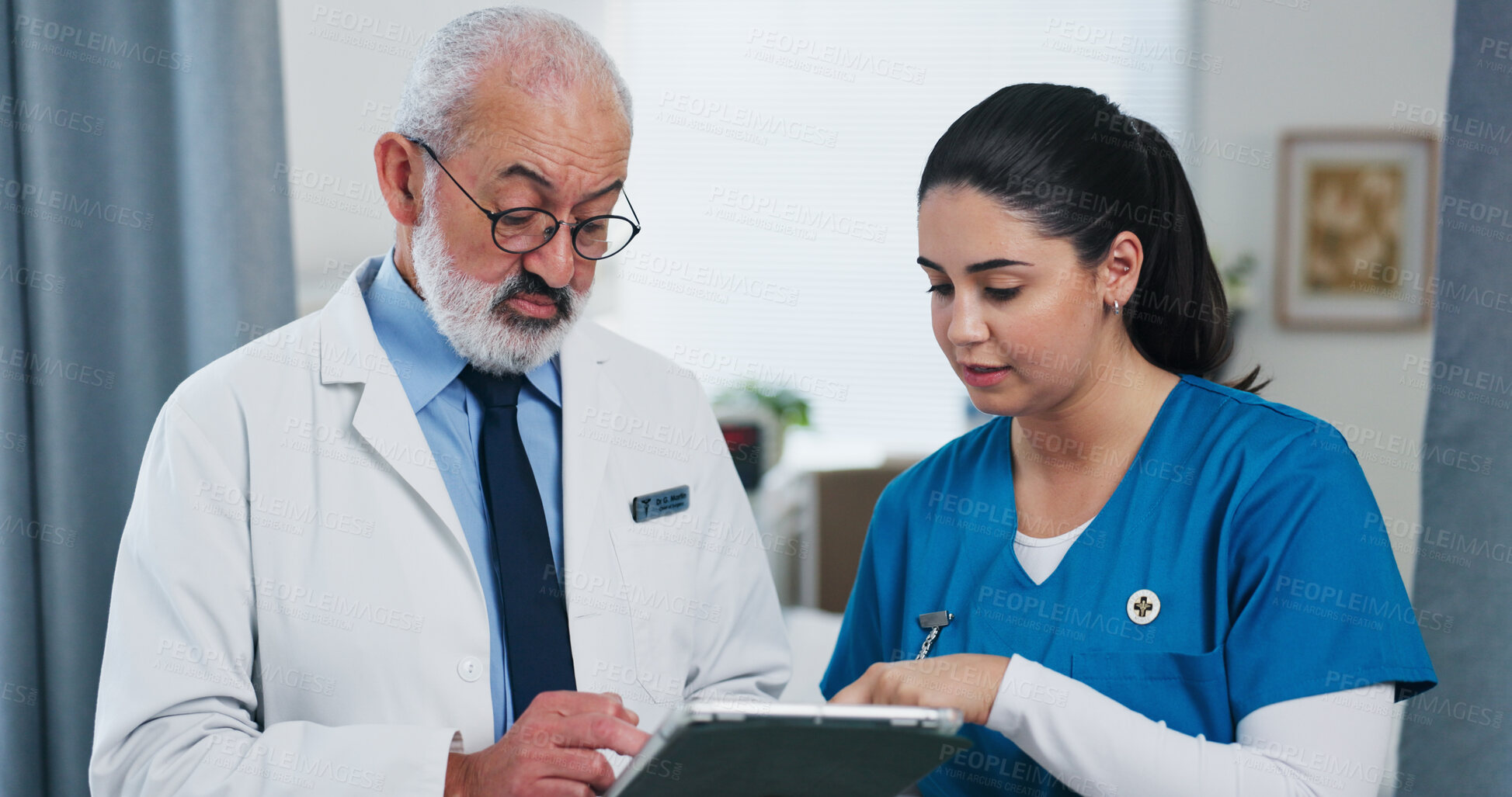 Buy stock photo Doctors, tablet and team with discussion at hospital with review, checklist or insight for medical report. Mature mentor, man and woman with tech, app and feedback for healthcare services at clinic