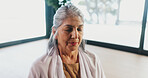 Mature woman, meditation and zen at yoga studio with eyes closed for breathing exercise on gym floor. Person, holistic fitness and mindfulness at club, class or posture with peace at wellness center