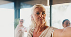 Mature woman, warrior pose and yoga class with group holistic fitness, zen and course at studio. People, meditation and mindfulness with circulation, breathing exercise or balance at wellness club