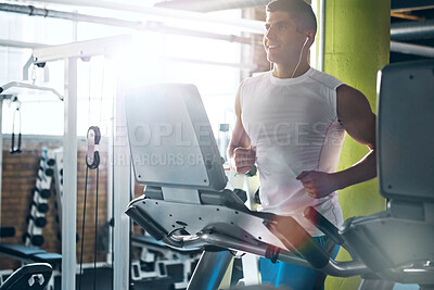 Buy stock photo Earphones, exercise and man running on treadmill for fitness, wellness and listening to audio in gym. Cardio machine, music and happy person training in health club for workout, challenge and flare