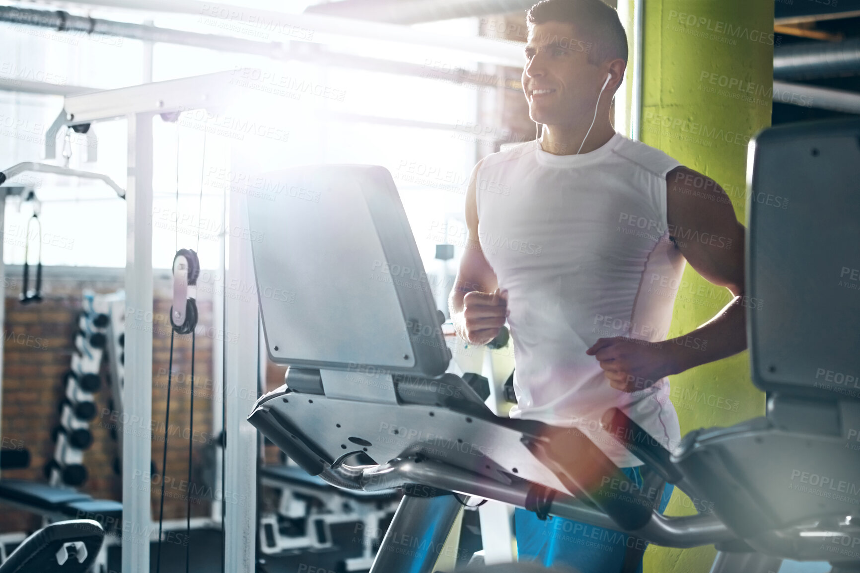 Buy stock photo Earphones, exercise and man running on treadmill for fitness, wellness and listening to audio in gym. Cardio machine, music and happy person training in health club for workout, challenge and flare