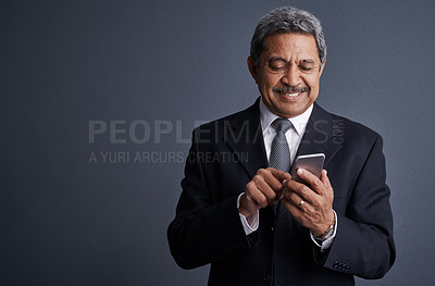 Buy stock photo Phone, smile and professional with business man in studio for realtor negotiation, network or chat. Communication, virtual property advisor or connection with mature person on dark background space