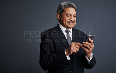 Buy stock photo Mature, businessman and studio with phone for social media, network or chat on a gray background. Happy man, employee or smile with mobile smartphone for online app, texting or connection on space