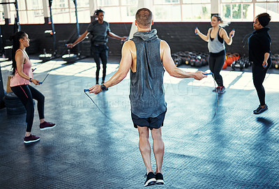 Buy stock photo Fitness, circle or people in gym class with jump rope, cardio workout or calorie burn in team training. Exercise, athletes or instructor with gear, group session or intense skipping for weight loss.