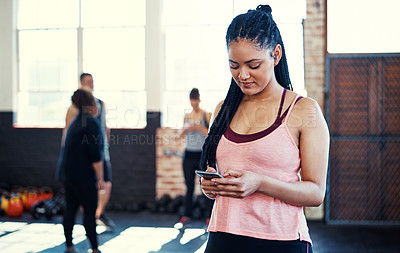 Buy stock photo Cellphone, fitness and woman in gym for class with texting, networking or contact on mobile app. Happy, technology and female person with phone for feedback on exercise routine in sports center.