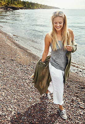 Buy stock photo Woman, walking and happy at beach, travel and laughing on adventure, tourism or fresh air on holiday. Outdoor, traveler and person with smile in nature, thinking and break on vacation, sea and space