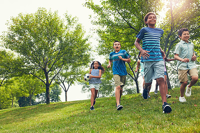 Buy stock photo Children, friends and excited with running at park with football, laugh and bonding on summer vacation. Kids, group and outdoor fun at playground with soccer ball, energy or low angle in nature