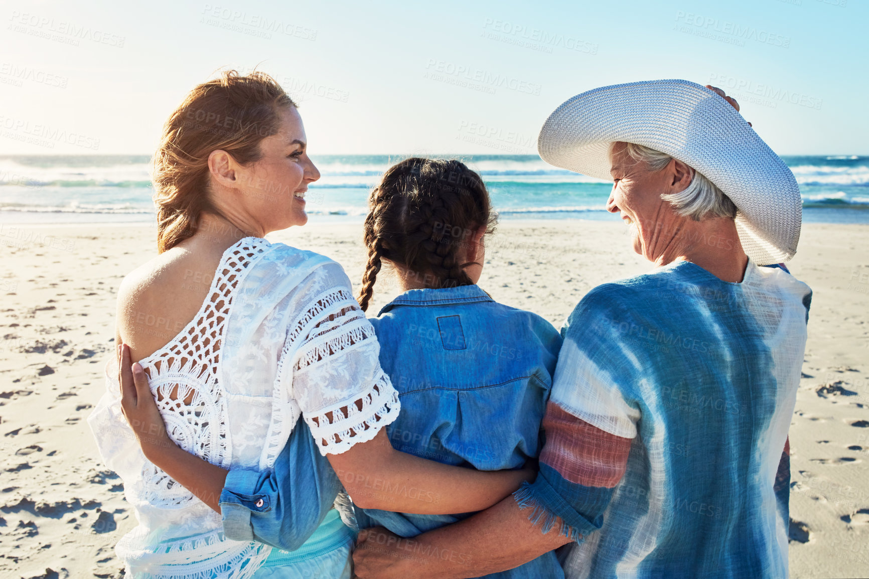 Buy stock photo Grandmother, mom and child at beach with hug for summer holiday, vacation and bonding outdoor. Family, generation and back of women with girl by ocean with embrace for relationship, love and travel