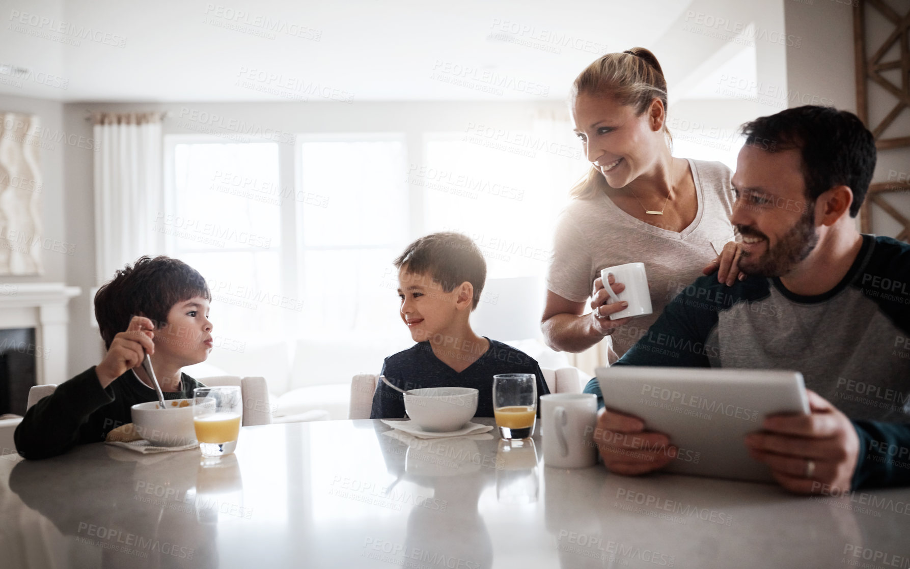 Buy stock photo Eating breakfast, children and parents in family home, health and relax with tablet for happiness. Mom, dad and kids with morning food for nutrition, love and care together with tech for development