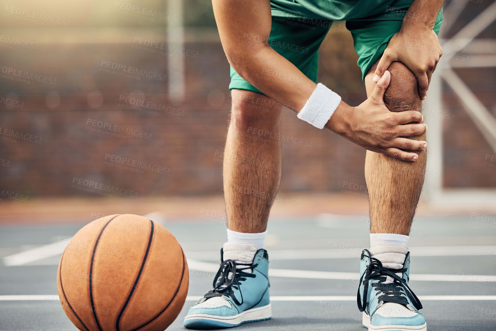 Buy stock photo Basketball, athlete and knee injury on the basketball court during outdoor game or training. Man in with leg pain after sports accident with a broken joint, inflammation or muscle tear during match.