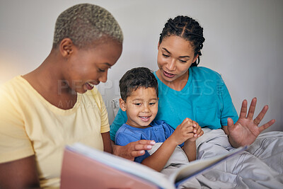 Buy stock photo Reading, LGBT family and child with a book in bed for knowledge, education and learning. Adoption, lesbian or gay women or parents and foster kid together in home bedroom with story for quality time
