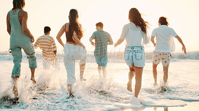 Buy stock photo People, friends and running with water splash on beach for summer vacation, sunset or playful day. Group, community or playing with waves on ocean coast or sea for weekend getaway or fun holiday