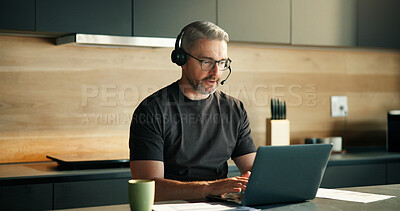 Buy stock photo Headset, laptop and remote work with man in kitchen of home for customer service or support. Computer, consulting and typing with mature freelancer in apartment for contact us, crm or problem solving