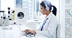 Scientist, laptop and woman with medical research, typing and healthcare for notes in laboratory. Headphones, doctor and report with chemist, test results or development with biotechnology study