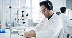 Scientist, document and man with medical research, writing and healthcare notes in laboratory. Headphones, doctor and report with chemist, test results or development for study or experiment planning
