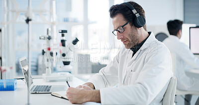 Buy stock photo Scientist, document and man with headphones, writing and healthcare notes in laboratory. Medical research, doctor and podcast with chemist, test results or development for study or experiment plan