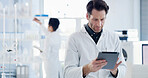 Scientist, tablet and man with medical research, reading and healthcare notes in laboratory. Thinking, doctor and report with chemist, test results or development for study or experiment planning