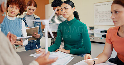 Buy stock photo Teaching, students and communication in classroom for education, science lesson and explain wind power. Learning, people and teenagers writing notes for knowledge, clean energy and turbine mechanics