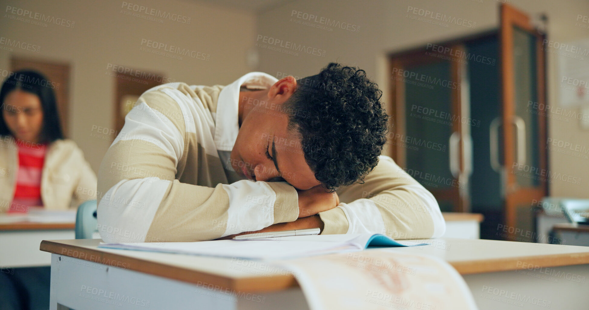 Buy stock photo Sleeping, education and student in classroom with test, exam or assignment with fatigue or burnout. Tired, learning and boy teenager in lesson with exhaustion for studying with quiz at school.