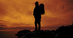 Sunset, hiking and silhouette of man on mountain for adventure, reflection and view of ocean. Trekking, backpacking and person outdoor for holiday, travel and thinking with space for sightseeing
