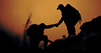 Silhouette, hiking and people with help, travel and support for hobby, adventure or fitness. Hiker, holding hands or friends with backpacking challenge, trekking journey or climbing cliff with sunset