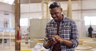 Buy stock photo Typing, carpenter and man in workplace, smartphone for social media and email for inventory. Happy person, entrepreneur and employee in factory, internet and cellphone for startup website and network