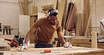 Carpentry, planning and black man with measuring wood in workshop for furniture development with precision. Tools, timber and African male carpenter with plank for woodworking or handicraft project.