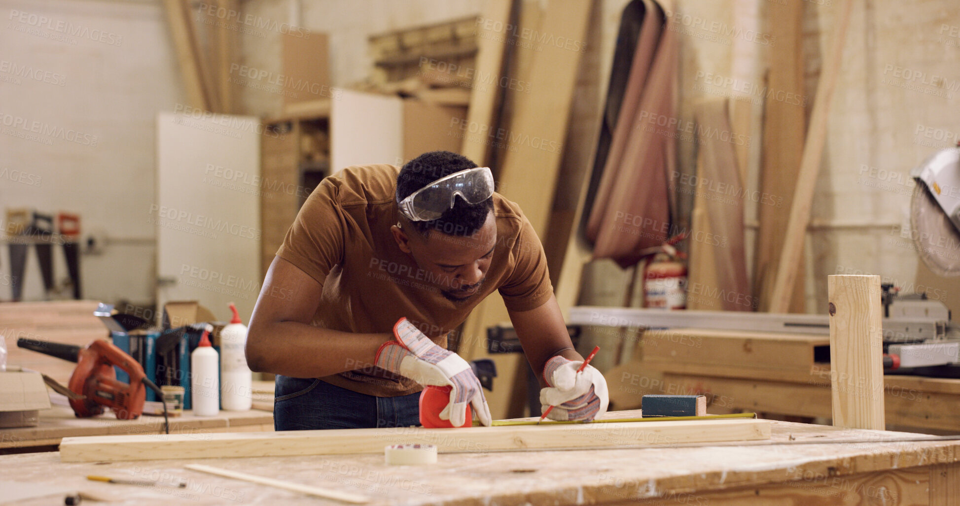 Buy stock photo Carpentry, writing and black man with tape measure in workshop, construction process and precision. Tools, woodworking and carpenter with plank for creative project, material preparation and craft
