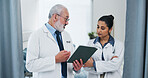 Doctors, tablet and team with review at hospital with discussion, checklist or insight for medical report. Mature mentor, man and woman with tech, app and feedback for healthcare services at clinic