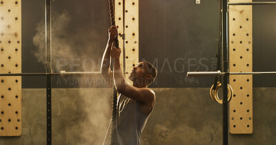 Buy stock photo Athlete, black man and climbing with rope at gym for fitness, intense exercise and weightlifting. Male person, powder and strong grip with gear for pull up, strength training and endurance challenge