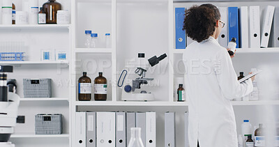 Buy stock photo Scientist, woman and reading bottle in lab with clipboard, review and medical research for drug trial. Back, person and science product in clinic with checklist, stock inspection and quality control.