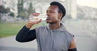 Buy stock photo Man, exercise and drinking water at beach on promenade, break or outdoor for hydration with wellness. African person, runner and bottle on boardwalk, electrolytes and fog with fitness in seaside city